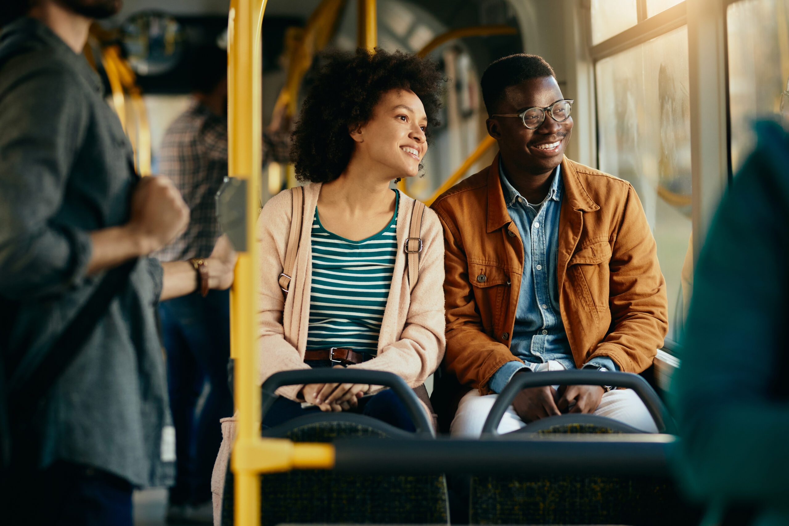 Happy black couple looking through the window while commuting by